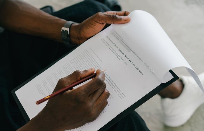 Close-up of a person writing on a psychological assessment form with a pencil.