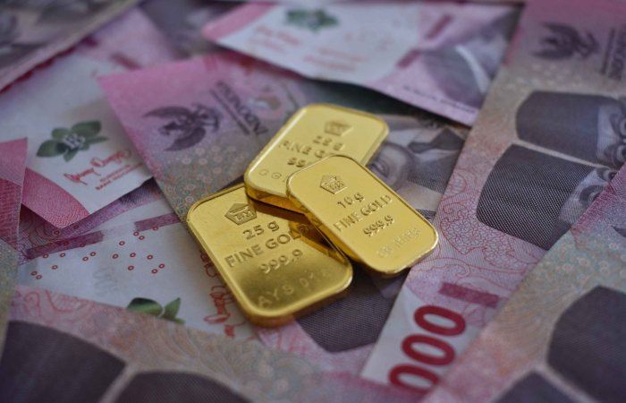 Close-up of gold bars on Thai baht banknotes, symbolizing wealth and prosperity.